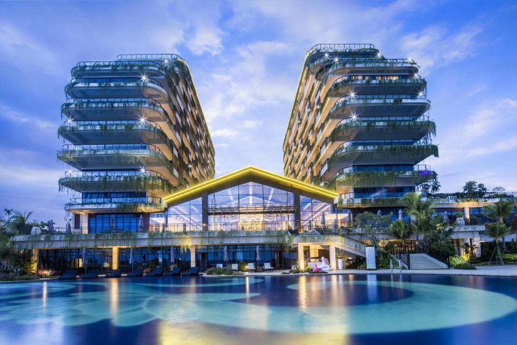 Forest City Golf Hotel illuminated beside the pool at blue hour