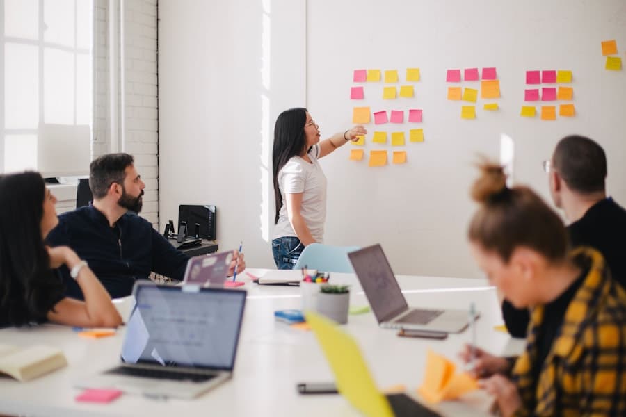 A team workshop arranged around shared tables and a planning wall