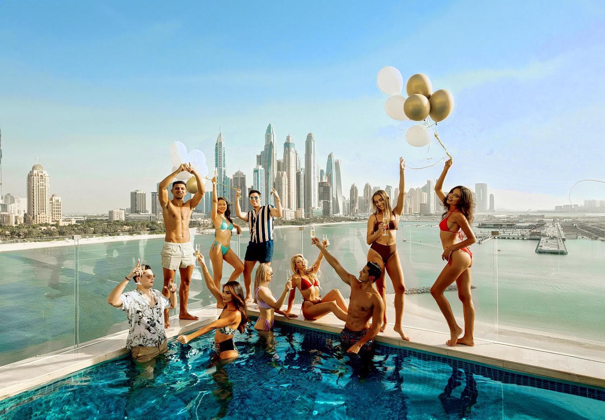 Members celebrating together by a rooftop pool with a city skyline